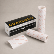 GUARDERM brand adhesive film rolls and packaging on a neutral beige background. The image shows the black and gold product box alongside two rolls of white adhesive film with a red grid pattern, and one loose strip of the film.