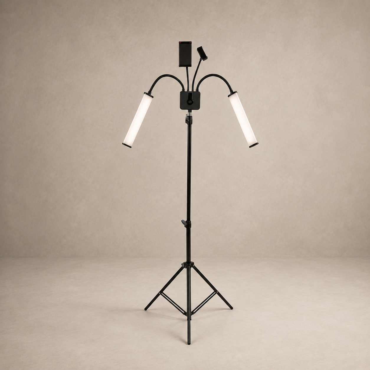 A black tripod floor lamp with two adjustable gooseneck arms and cylindrical white diffusers, shown against a neutral beige studio backdrop.