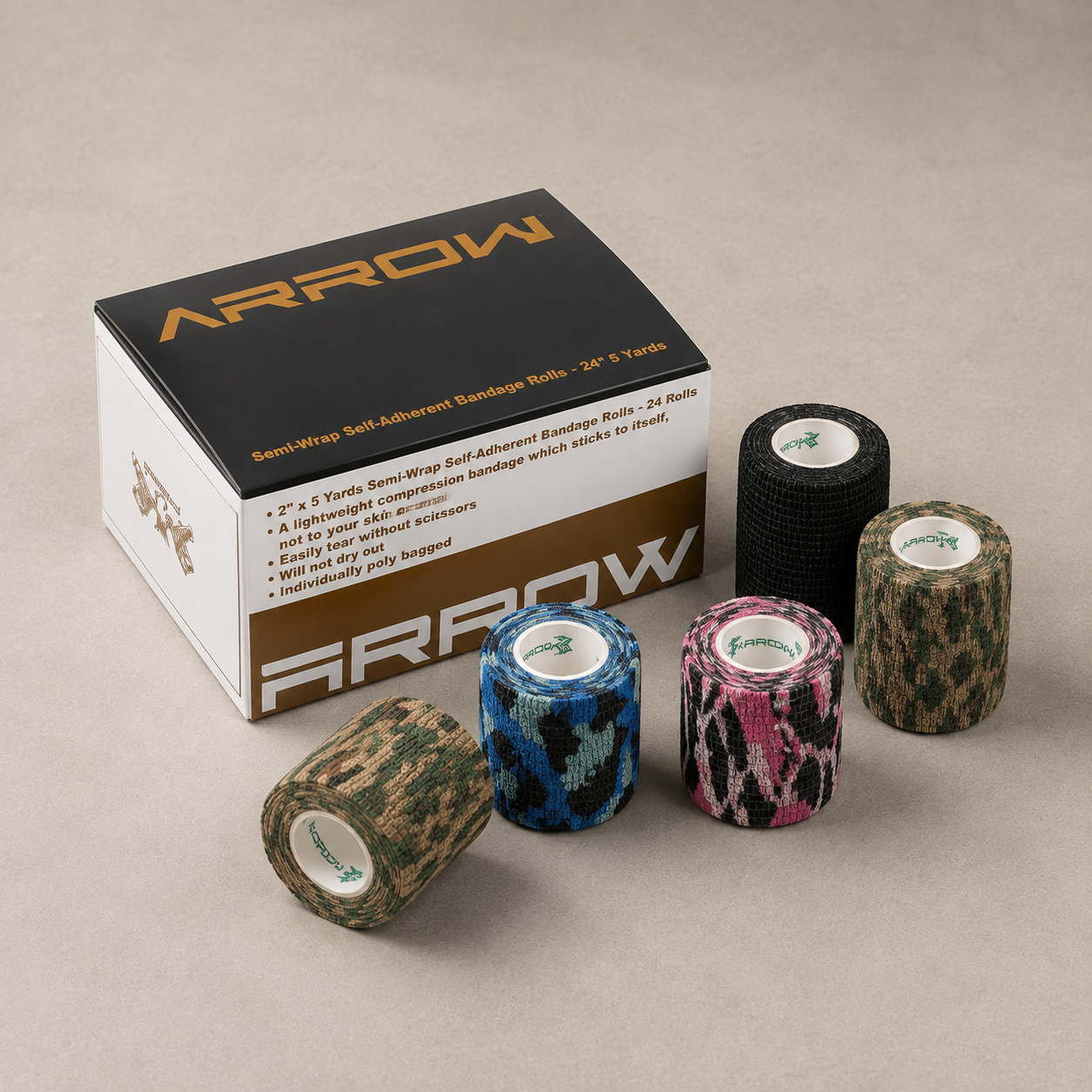 Arrow brand semi-wrap soft adhesive bandage rolls displayed in front of their product box on a neutral beige background. The box is black and white with gold branding, and the bandage rolls show various camouflage and patterned designs in green, blue, pink, and black.