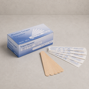 A box of wooden tongue depressors with several wooden sticks and five individually wrapped sticks displayed on a neutral beige surface.